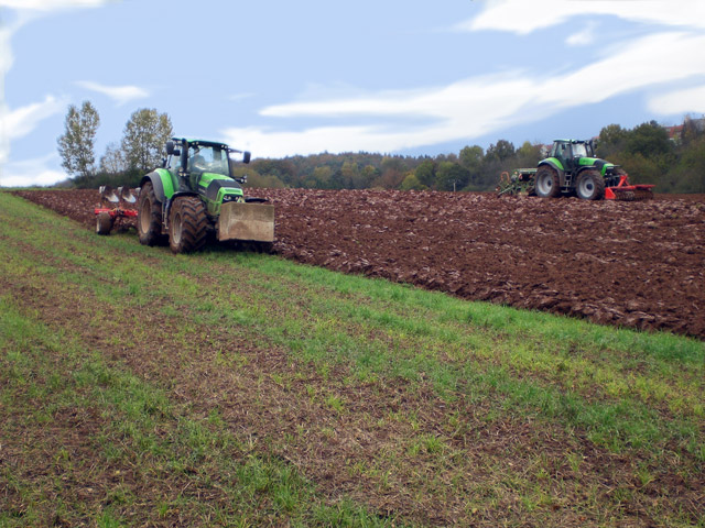 Zwei Traktoren ackern ein Feld